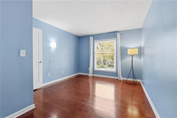 an empty room with wooden floor and window