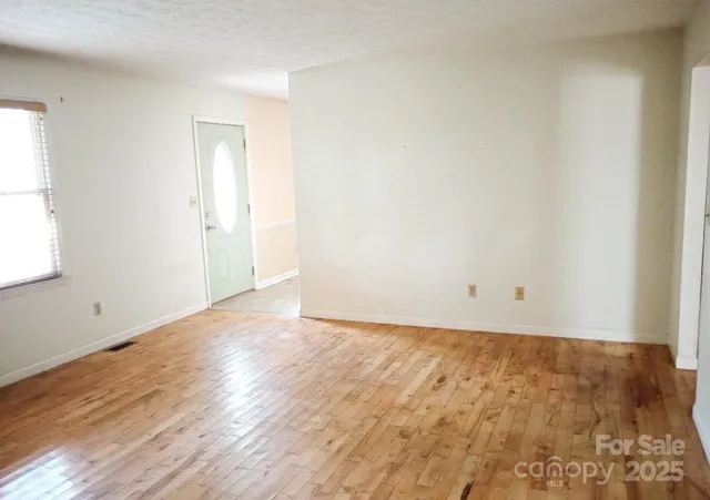a view of an empty room and wooden floor