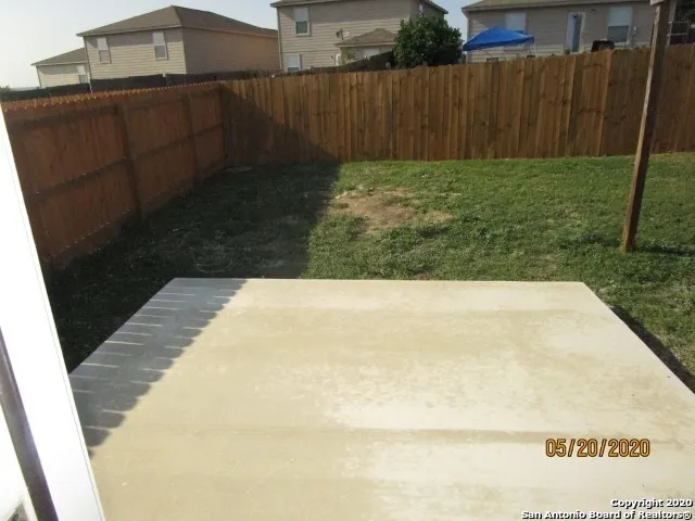 a view of backyard with wooden fence