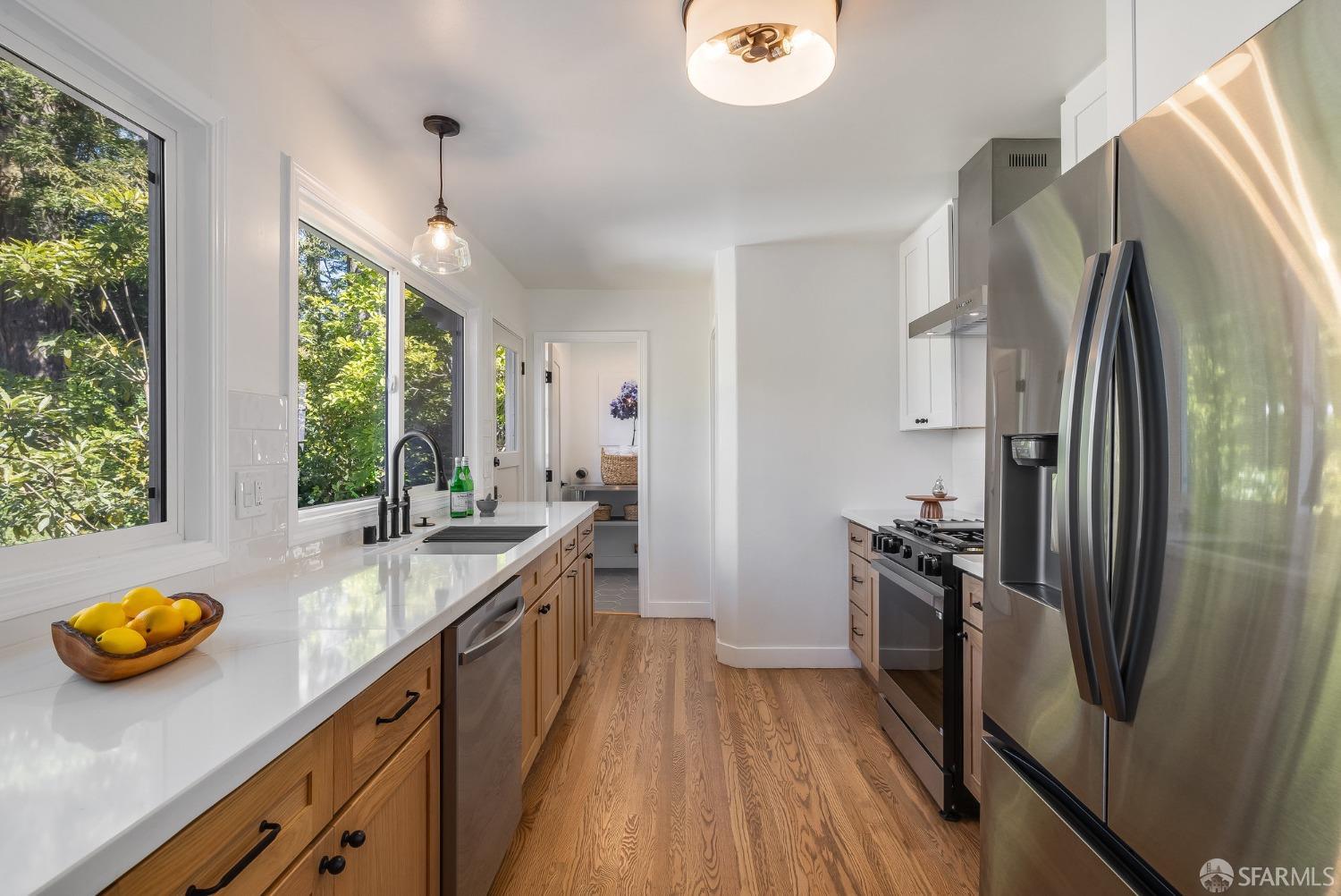 771 Creston Road Berkeley, CA 94708 - Photo 19 of 45 a kitchen with stainless steel appliances granite countertop a sink a stove and a wooden floors