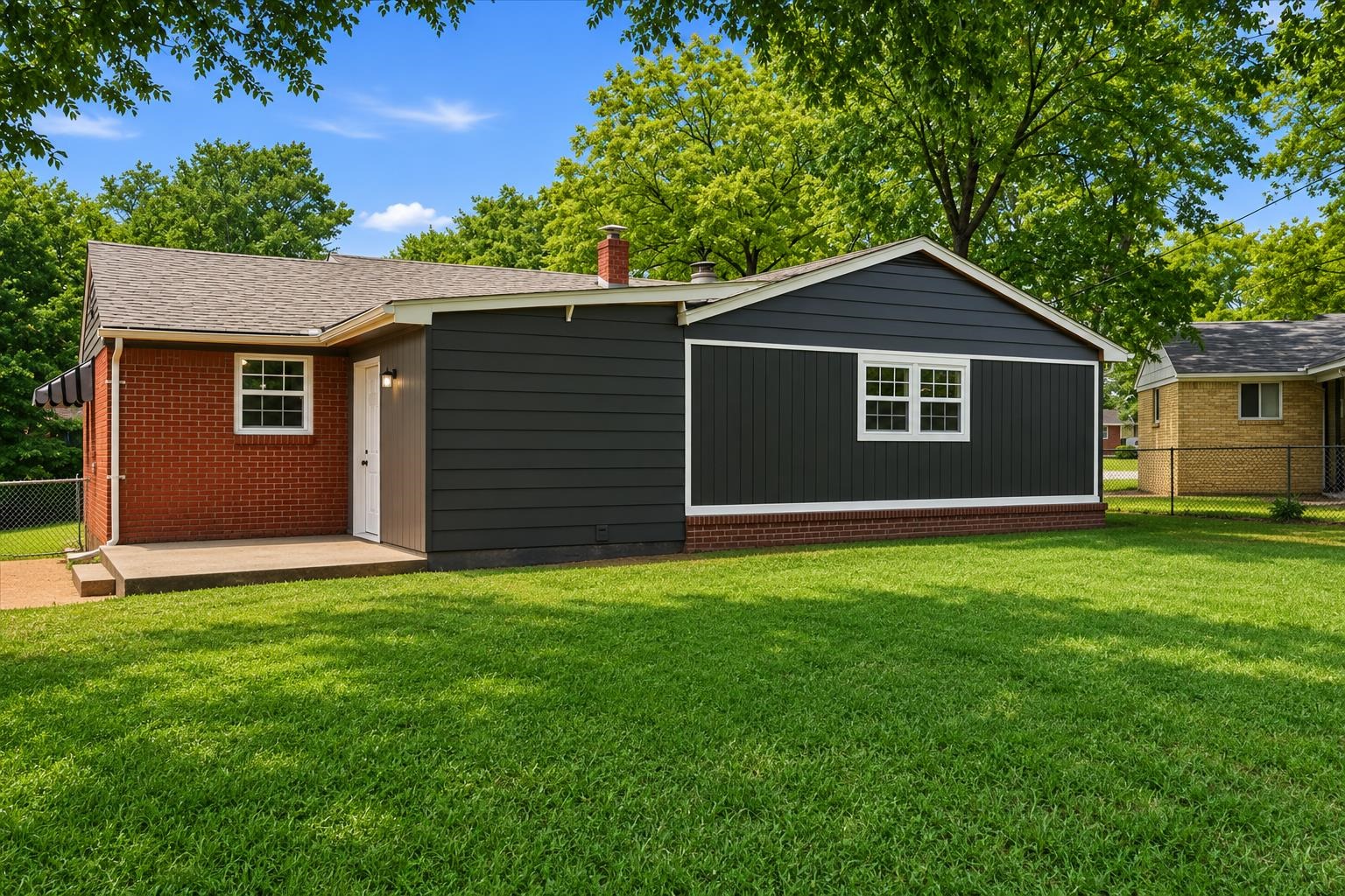 1176 South White Station Road Memphis, TN 38117 - Photo 3 of 15 Spacious green lawn surrounding a residence with a red brick facade and dark siding accents