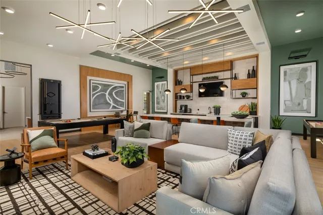 a living room with furniture a flat screen tv and kitchen view