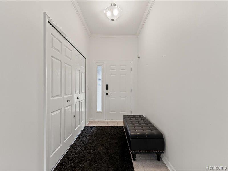 29213 Rachid Lane New Baltimore, MI 48047 - Photo 4 of 26 Doorway to outside with tile patterned flooring and crown molding