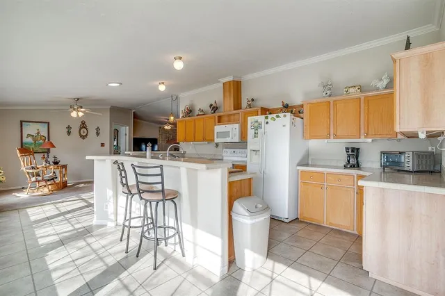 a kitchen with granite countertop appliances a sink and a refrigerator
