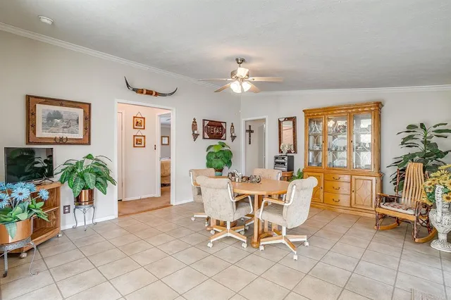 a dining room with furniture potted plants and a view of bedroom