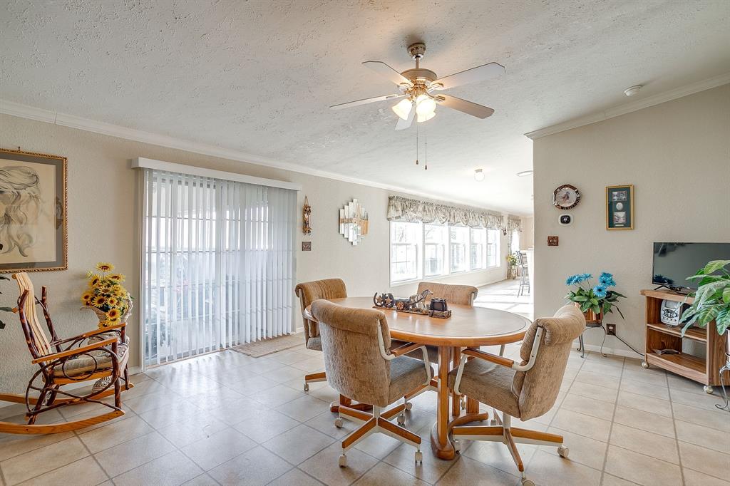 6724 Midway Road Springtown, TX 76082 - Photo 17 of 39 a dining room with furniture potted plants and wooden floor