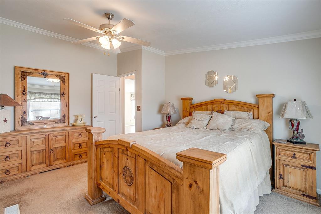 6724 Midway Road Springtown, TX 76082 - Photo 26 of 39 a bedroom with a bed and a chandelier