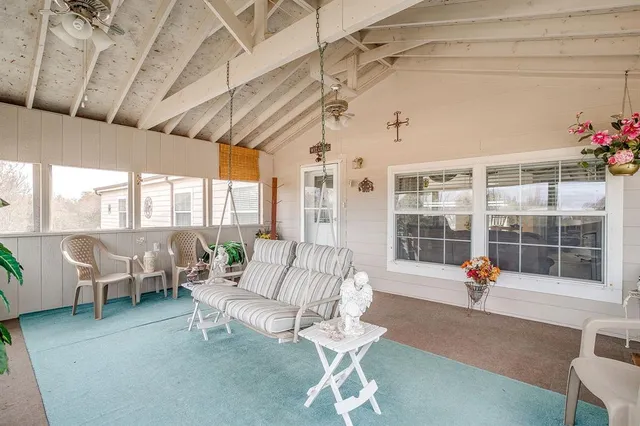 a living room with patio furniture and a chandelier
