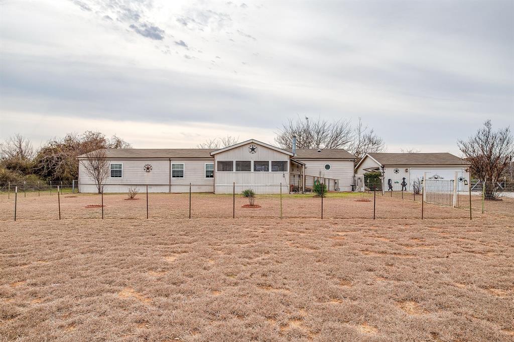 6724 Midway Road Springtown, TX 76082 - Photo 6 of 39 a white house with a big yard and large trees