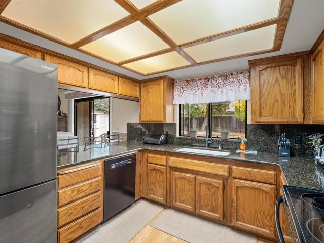 a large kitchen with stainless steel appliances granite countertop a sink and cabinets