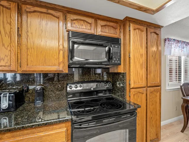 a kitchen with granite countertop cabinets stainless steel appliances and a counter space
