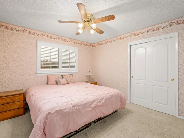 a bedroom with a bed and a ceiling fan