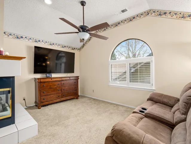 a living room with furniture a flat screen tv and a window