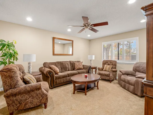 a living room with furniture and a ceiling fan