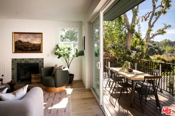 a living room with fireplace furniture and a large window