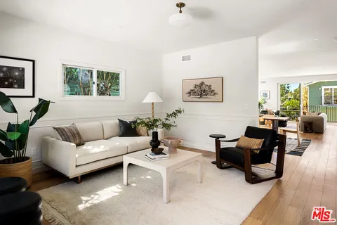 a living room with furniture potted plant and a chandelier