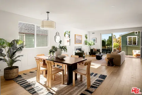 a living room with fireplace furniture large windows and wooden floor