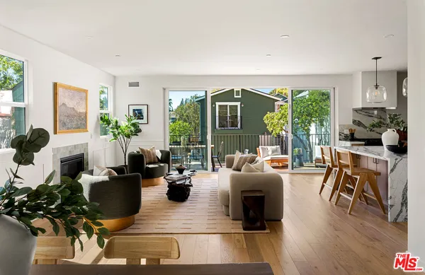 a living room with furniture fireplace and a large window