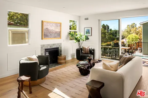 a living room with furniture a fireplace and a window