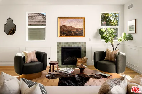 a living room with furniture a fireplace and a potted plant