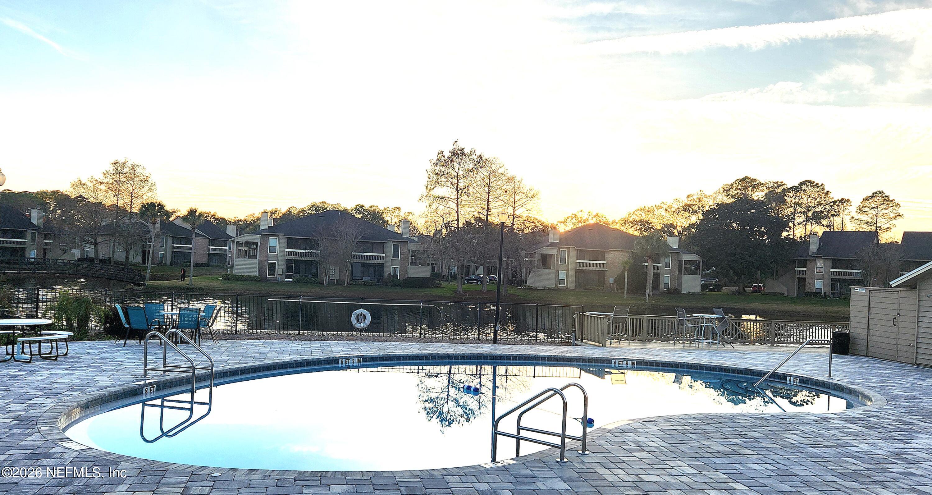 10200 Belle Rive Boulevard, Unit 96 Jacksonville, FL 32256 - Photo 18 of 19 a view of a swimming pool with a table and chairs