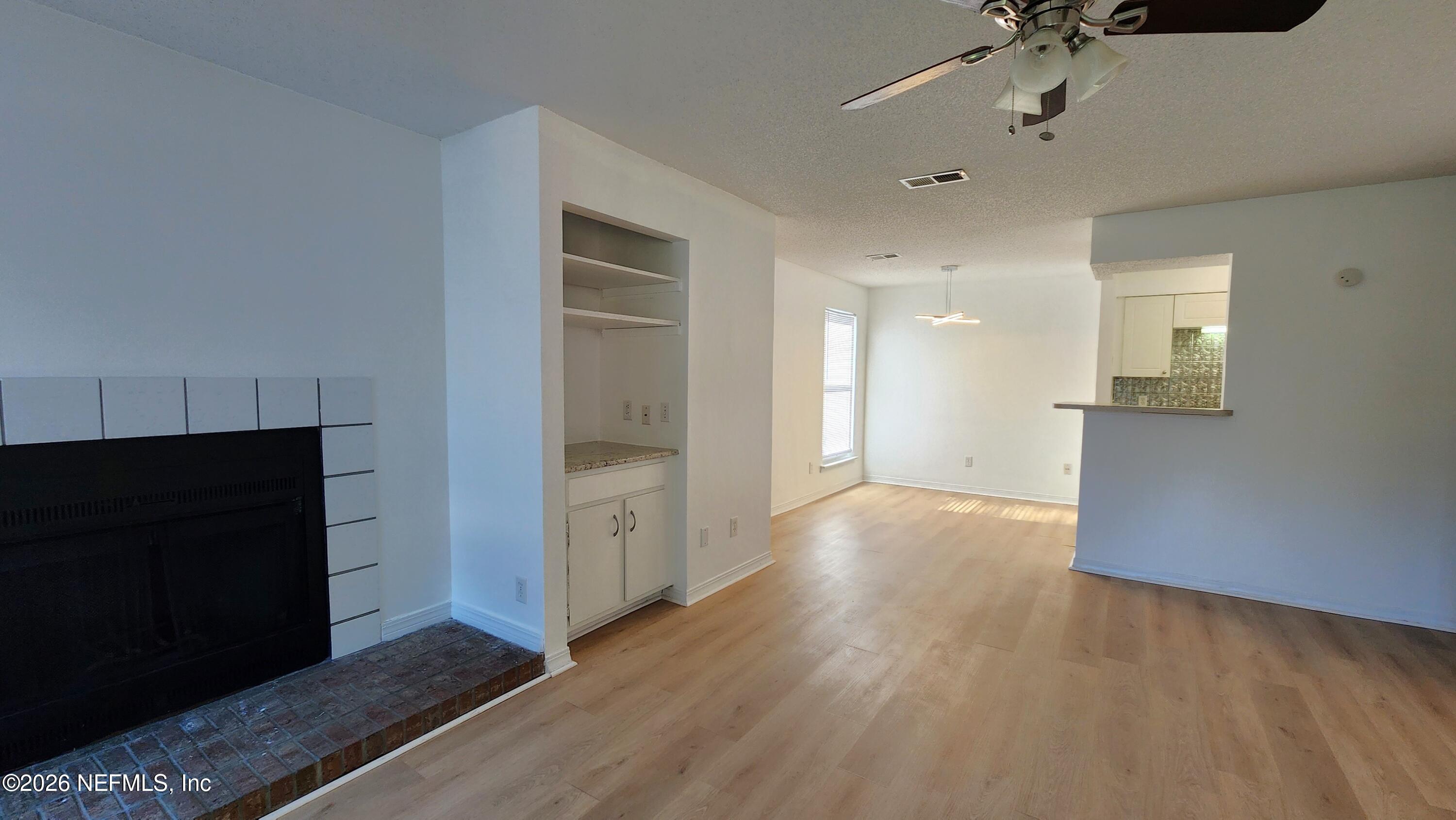 10200 Belle Rive Boulevard, Unit 96 Jacksonville, FL 32256 - Photo 2 of 19 a view of a hallway with wooden floor and a cabinet