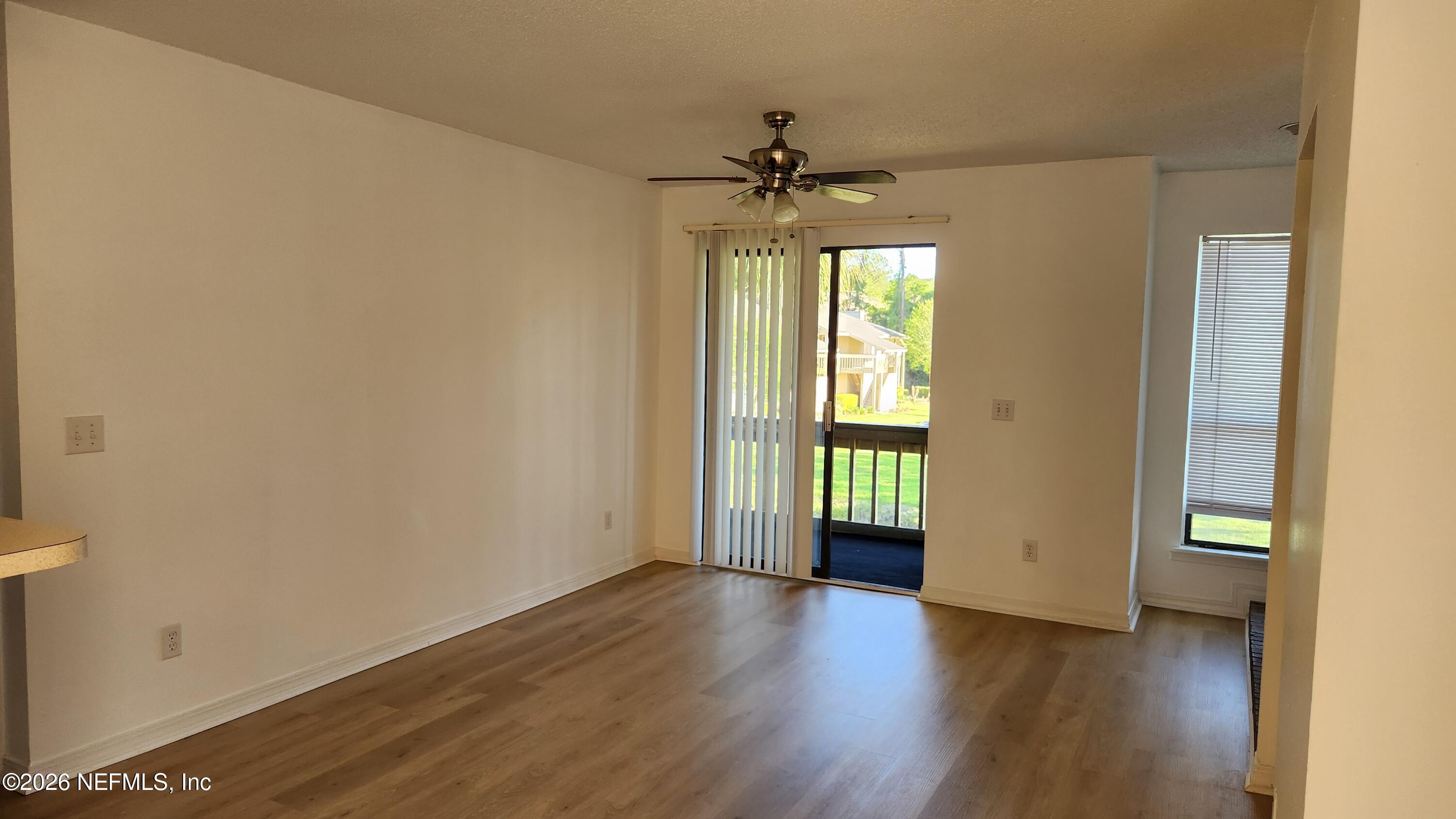 10200 Belle Rive Boulevard, Unit 96 Jacksonville, FL 32256 - Photo 10 of 19 an empty room with wooden floor a ceiling fan and windows