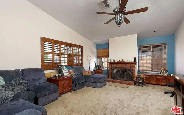 a living room with furniture a ceiling fan and a window