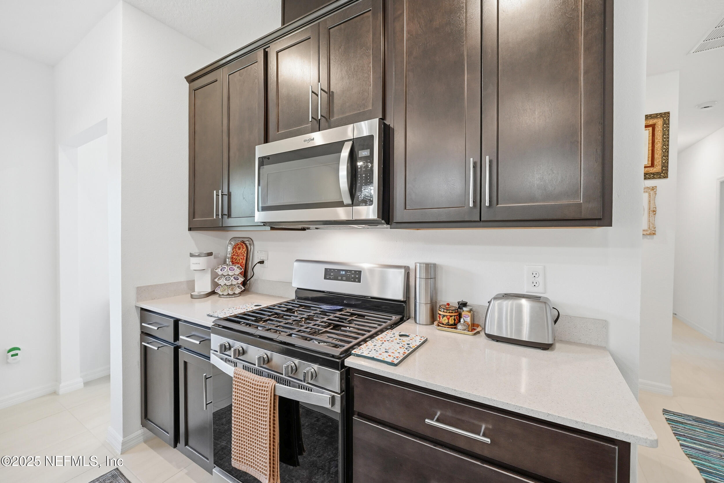 607 Blind Oak Circle St. Augustine, FL 32095 - Photo 8 of 39 a kitchen with stainless steel appliances granite countertop a sink stove and microwave