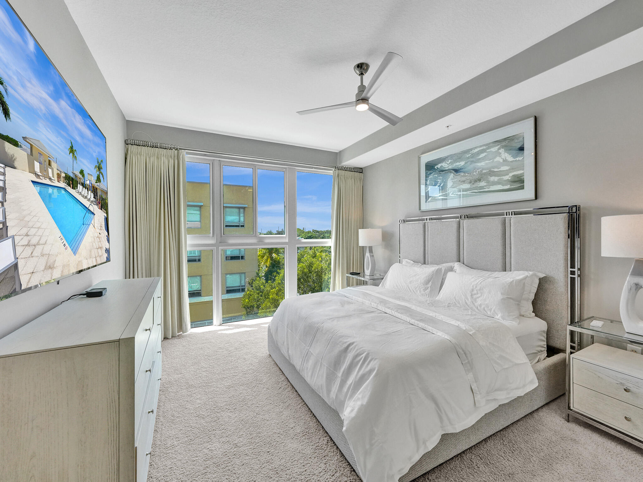 225 Northeast 1st Street, Unit 412 Delray Beach, FL 33444 - Photo 30 of 49 a bedroom with a large bed and a flat tv screen on dresser