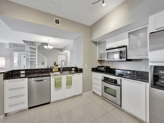 a kitchen with granite countertop stainless steel appliances a stove sink and microwave