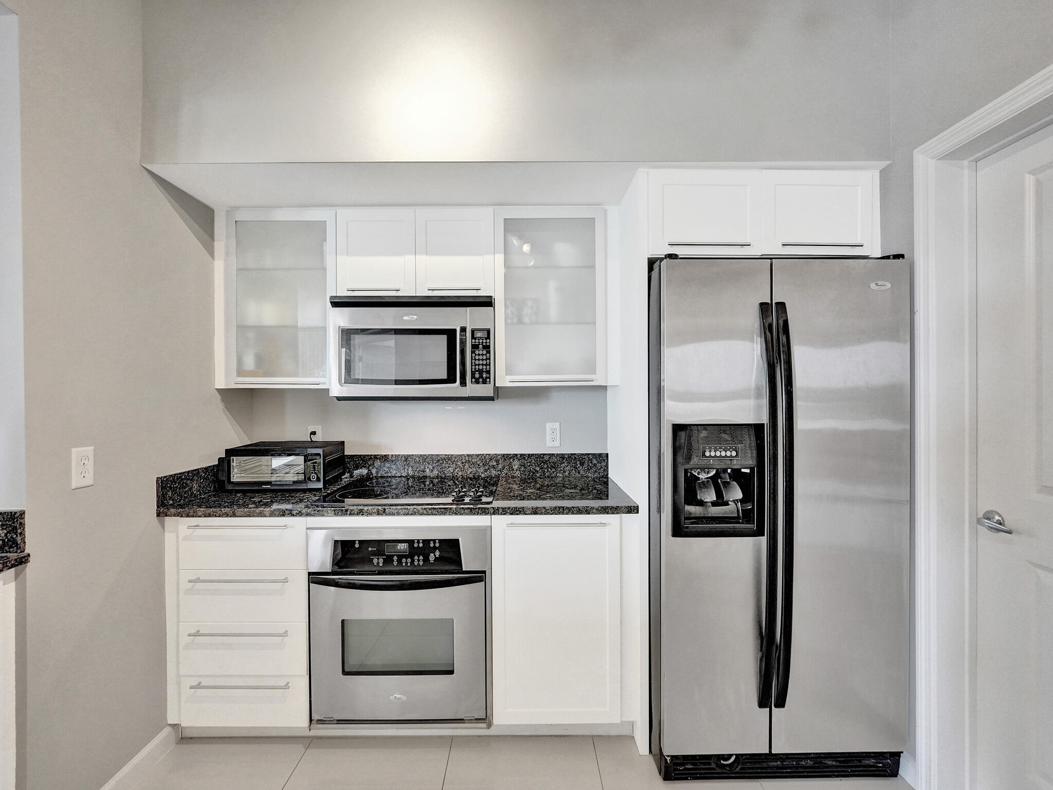225 Northeast 1st Street, Unit 412 Delray Beach, FL 33444 - Photo 9 of 49 a kitchen with stainless steel appliances granite countertop a stove and a refrigerator