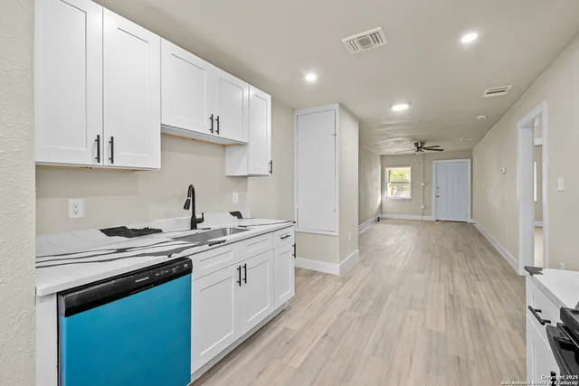 a kitchen with cabinets wooden floor and a sink