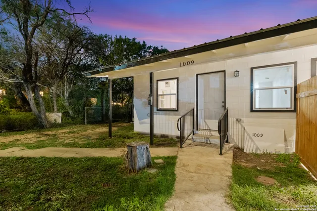 a backyard of a house with table and chairs