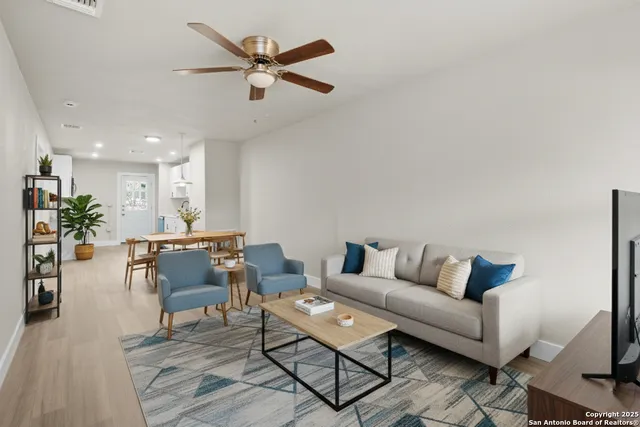 a living room with furniture and a wooden floor