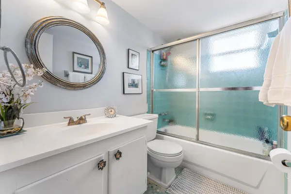 a bathroom with a sink a toilet and a mirror