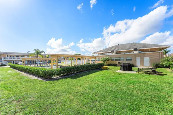 a view of a big building with a big yard and large trees
