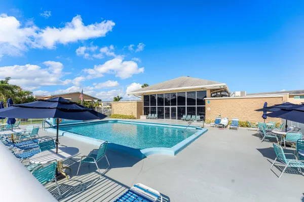 a view of a house with pool and chairs