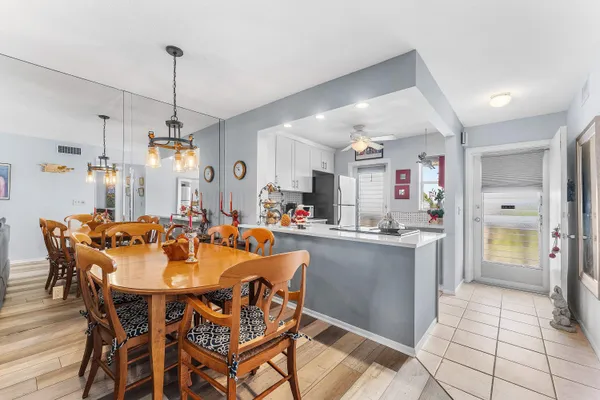 a view of a dining room and livingroom with furniture wooden floor a chandelier