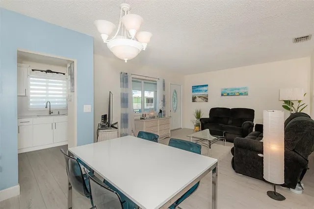 a view of a dining room with furniture and chandelier