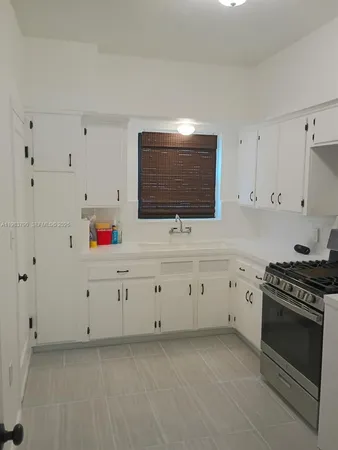 a kitchen with white cabinets stainless steel appliances and sink