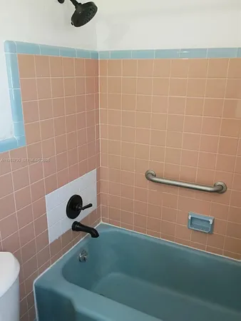 a white toilet sitting next to a shower curtain