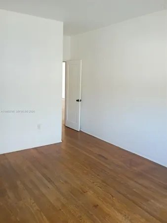 a view of a hallway with wooden floor and closet