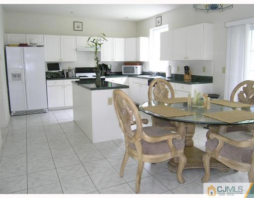 40 Timber Ridge Road North Brunswick, NJ 08902 - Photo 4 of 8 a kitchen with stainless steel appliances granite countertop a stove a refrigerator a sink a dining table and chairs