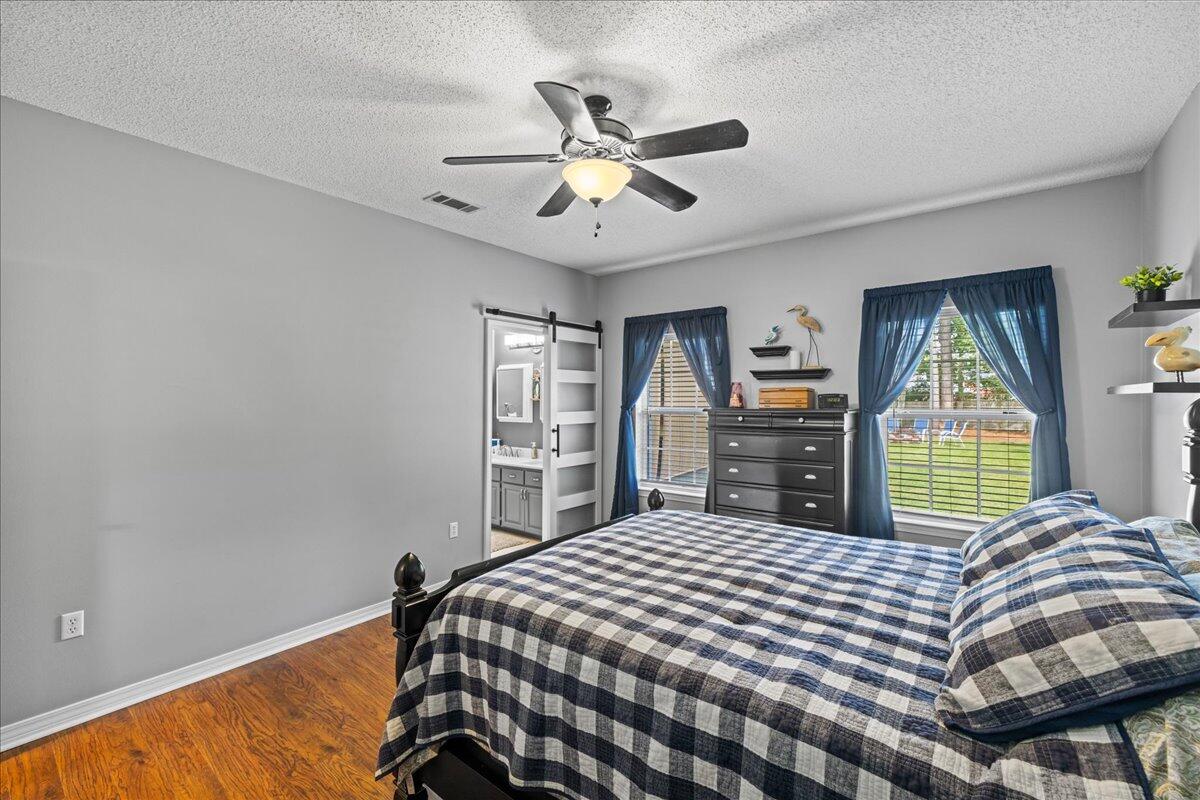 306 Tala Way Niceville, FL 32578 - Photo 25 of 47 a bedroom with a large bed and a chandelier