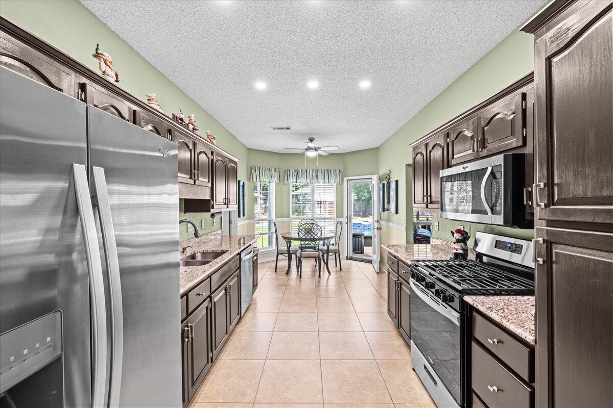 306 Tala Way Niceville, FL 32578 - Photo 8 of 47 a kitchen with stainless steel appliances granite countertop a refrigerator and a stove