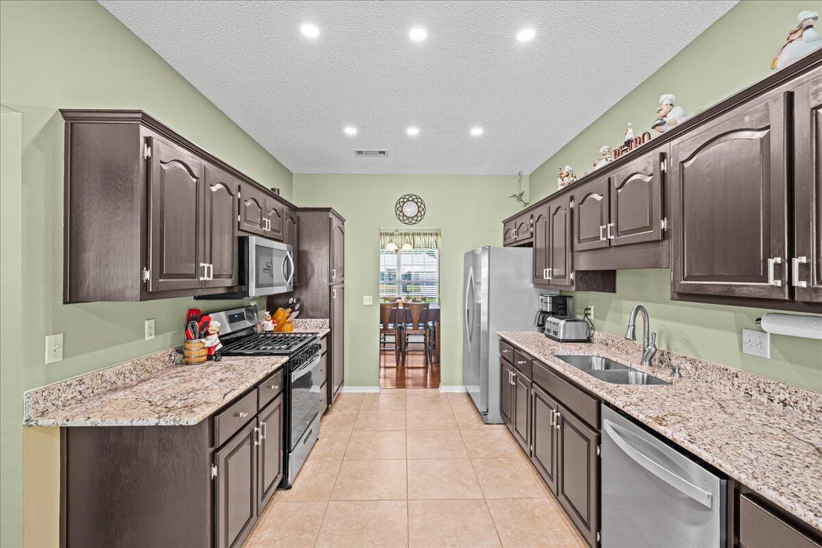 306 Tala Way Niceville, FL 32578 - Photo 9 of 47 a kitchen with stainless steel appliances granite countertop a sink stove and cabinets