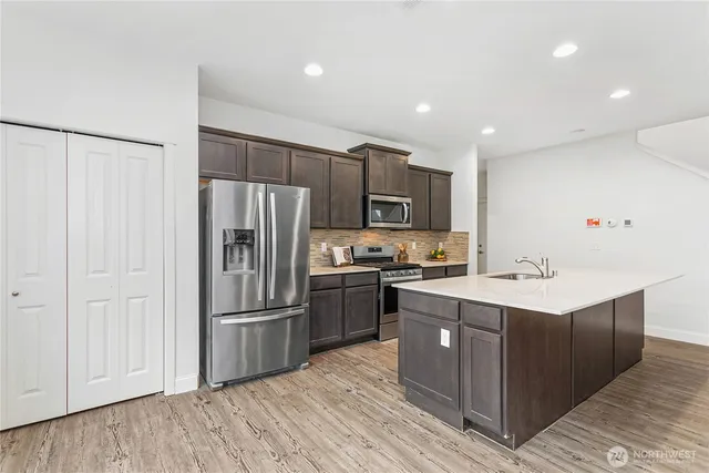 a kitchen with kitchen island a sink stainless steel appliances and cabinets