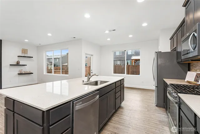 a kitchen with kitchen island a sink stove and refrigerator