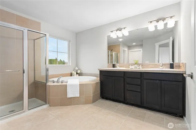 a bathroom with a double vanity sink mirror and bathtub